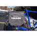 Blue bicycle with a gray Hikase bag attached to the rear wheel on a snowy street.